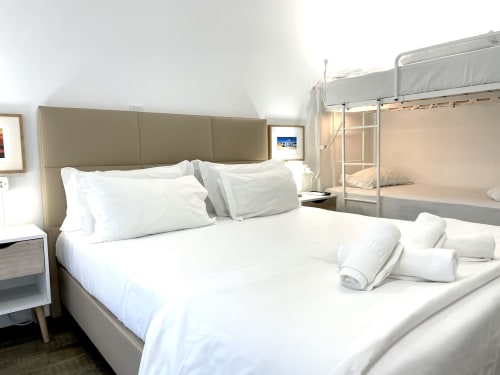Bright hostel room at Vila Alexandra, Costa da Caparica with double bed, bunk bed, white linens, and modern amenities