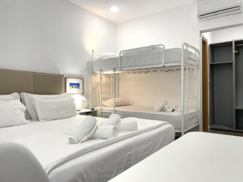 Modern hostel room at Vila Alexandra, Costa da Caparica with bunk bed, single bed, TV, and air conditioning