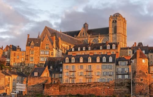 Hôtel Henri II au Mans, France avec la cathédrale historique et les bâtiments en terre cuite au coucher du soleil