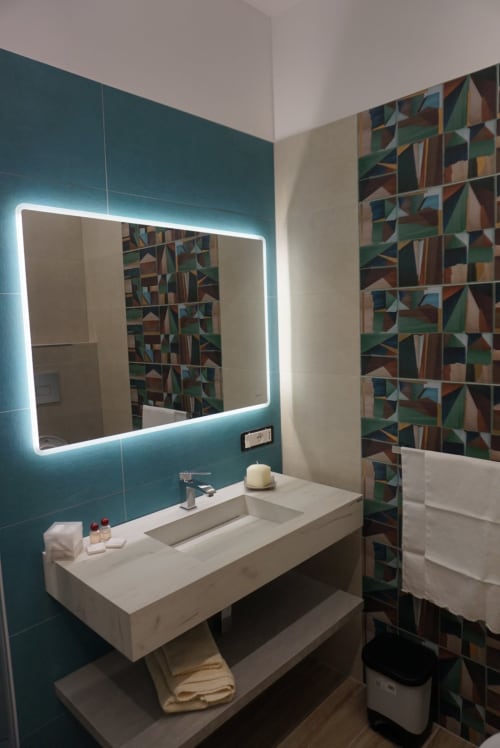 Bagno moderno a La Dimora Di Ipno a Vallata con parete accento teal, specchio illuminato e piastrelle geometriche