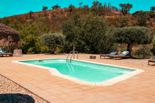 Piscina turquesa em Corvatos Casas do Monte com pátio em terracota e oliveiras, Almodôvar
