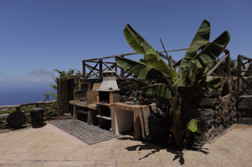 Rustic outdoor kitchen with banana plants and mountain views at Casonas de Marengo, Icod de los Vinos