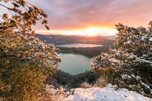 Laghi alpini circondati da alberi innevati al tramonto vicino a Vallata, Italia