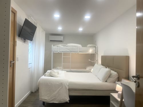 Vila Alexandra hostel room with double bed, bunk beds, TV, and AC in Costa da Caparica