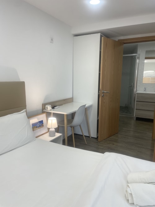 Vila Alexandra hostel room in Costa da Caparica with bed, desk, chair, and kitchenette with modern amenities