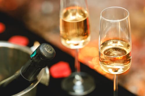 Verres de vin aux boissons dorées et bouteille à la villa Domaine du Haut de la Dombes, Châtillon-sur-Chalaronne