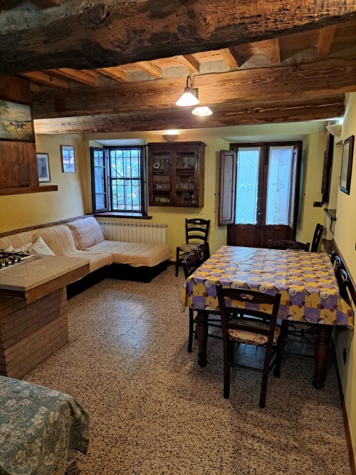Rustic B&B room at Corte Pincione in Montecarlo with wooden beams, dining table, and comfortable seating