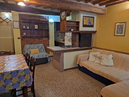 Corte Pincione common area in Montecarlo with kitchen, fireplace, sofas and rustic wood beams