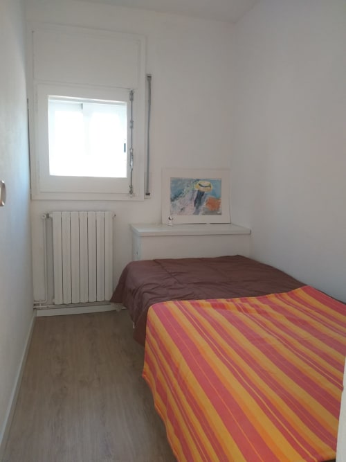Habitación sencilla en el hotel Finques Garcia Enrich en Palafrugell con cama, ventana, radiador y arte mural