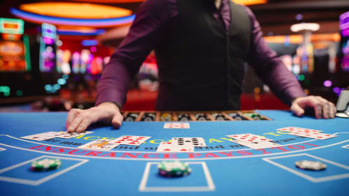 Blackjack dealer at casino table with cards and chips in Brides-les-Bains