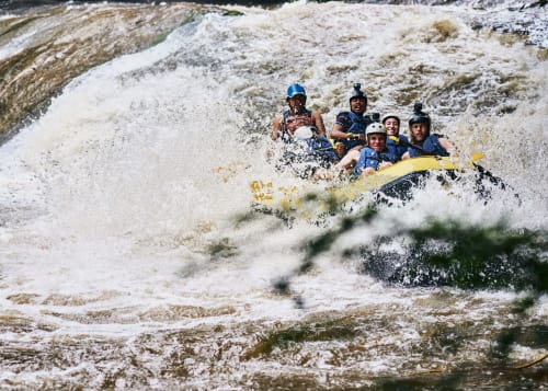 Group white water rafting through turbulent rapids near Brides-les-Bains