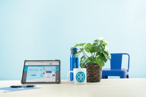 Modern workspace at Vila Alexandra hostel in Costa da Caparica with tablet, blue accessories, plant, and office supplies