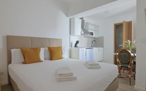 Modern studio apartment at Vila Alexandra hostel in Costa da Caparica with bed, kitchenette, and contemporary furnishings