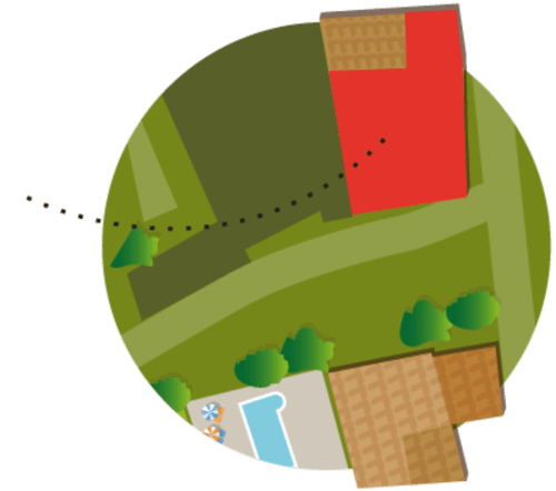 Vista aérea del alojamiento rural Can Gat Vell en Girona, con casa roja, terrenos verdes, árboles y caminos en Empordà-Cataluña