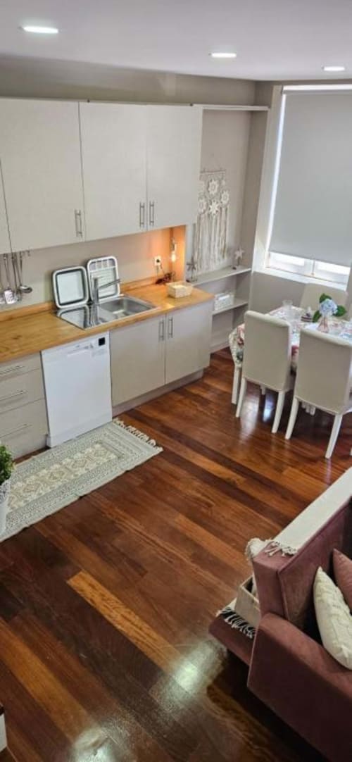 Cozinha moderna e sala de jantar em apartamento de 2 quartos na Casa Da Avó Ilda, Matosinhos com piso de madeira e vista para a cidade