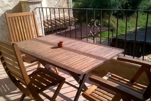 Juego de comedor de terraza de madera en Can Gat Vell B&B en Girona, Empordà, con vistas al campo