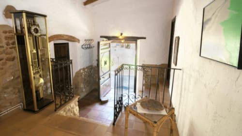 Habitación rústica en Can Gat Vell B&B en Girona con paredes de piedra vista, barandillas de hierro y mobiliario tradicional