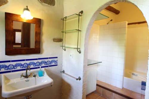 Baño del alojamiento rural Can Gat Vell en Girona con lavamanos, ducha abovedada y detalles de azulejos azules
