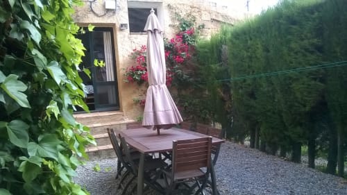 Área de comedor al aire libre con sombra en Can Gat Vell B&B en Girona, con mesa, sillas y sombrilla