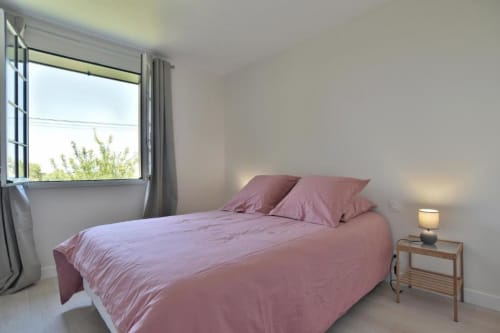 Chambre lumineuse avec literie rose à la villa Maison Grand Large à Saint-Cast-le-Guildo, vue sur le jardin
