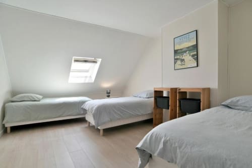 Chambre triple avec lits en bois dans la villa Maison Grand Large à Saint-Cast-le-Guildo, vue sur le jardin