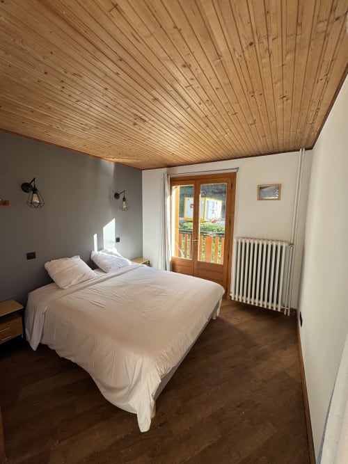 Chambre double confortable à l’Ardesia Morzine avec salle de bain privée et vue sur la montagne. Chambre double cosy à Ardesia Morzine, parfait pour un séjour en couple