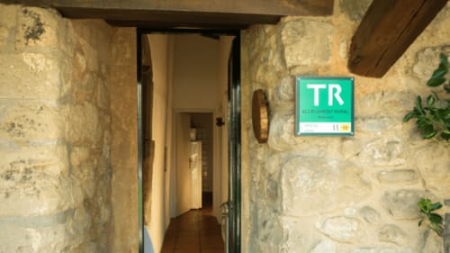 Entrada rústica de piedra en la casa rural Can Gat Vell en Gerona, Cataluña con señal verde TR