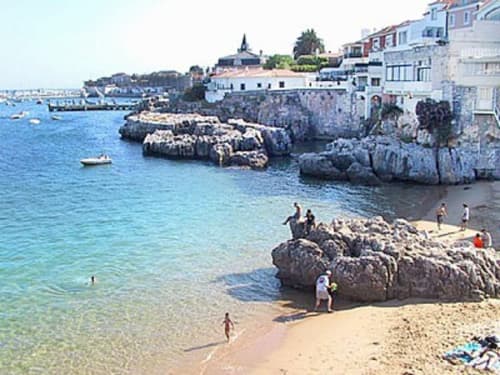 Praia costeira pitoresca de Cascais com casas Juromenha, pequenas enseadas rochosas, água turquesa e edifícios caiados