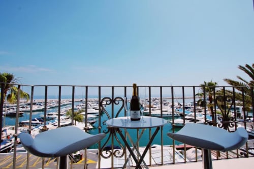 Penthouse balcony overlooking Puerto Banús marina with champagne, Marbella