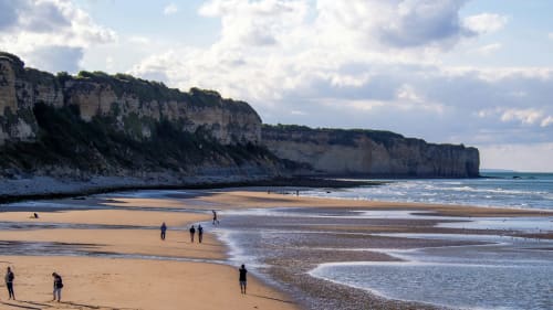 Plage de sable blanc avec falaises calcaires et eaux turquoise près de Bayeux - destination côtière idéale