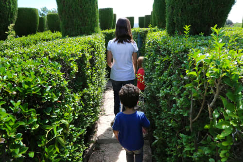 Femme et enfants traversant un labyrinthe de haies dans le jardin de l'hôtel Le 58 Bayeux à Bayeux, France