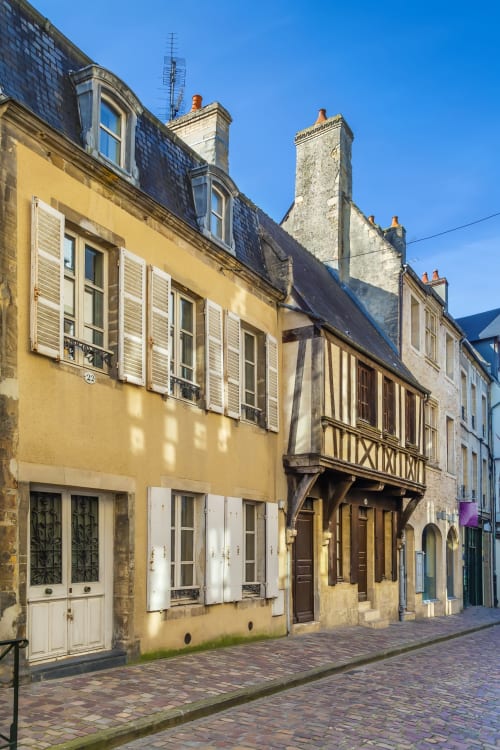 Le 58 Bayeux, bâtiment historique en pierre jaune sur une charmante rue de Bayeux, France