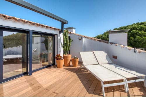 Terraza con vistas en Finques Garcia Enrich en Palafrugell con tumbonas, plantas en macetas y panorámica de las colinas