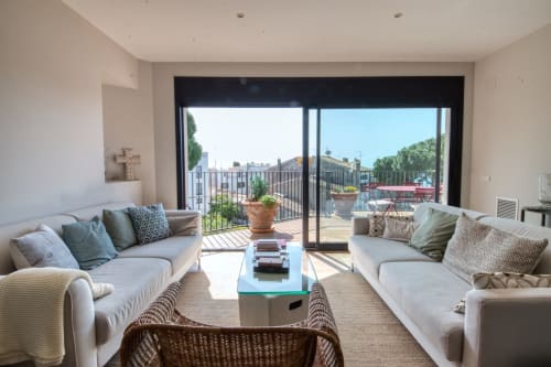 Moderna sala de estar con dos sofás frente a la terraza del hotel Finques Garcia Enrich en Palafrugell, vistas mediterráneas