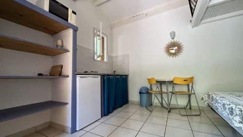 Studio villa à Le Maquis Plage avec kitchenette, coin repas, lit et rangements bleus à Poggio-Mezzana