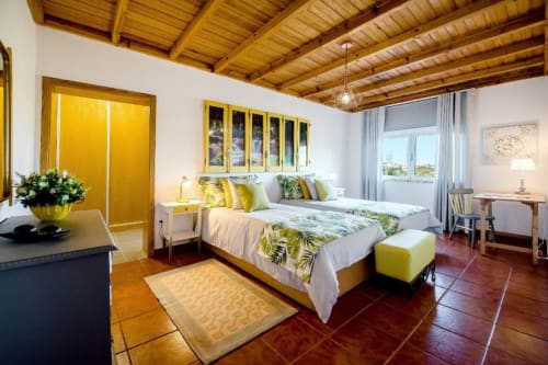 Bright Superior Twin bedroom at Home Alliance in Óbidos with yellow accents, wooden beams, twin beds, and modern amenities