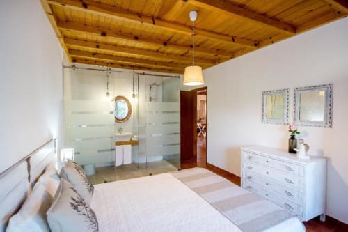 Modern bedroom at Home Alliance B&B in Bombarral with wooden ceiling, queen bed, ensuite bathroom with glass shower