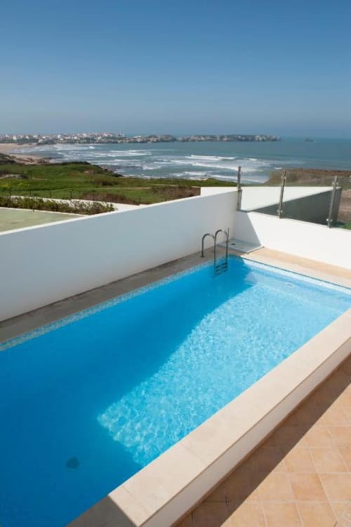 Private pool overlooking Atlantic Ocean beach and coastal town in Baleal, Portugal, luxury villa