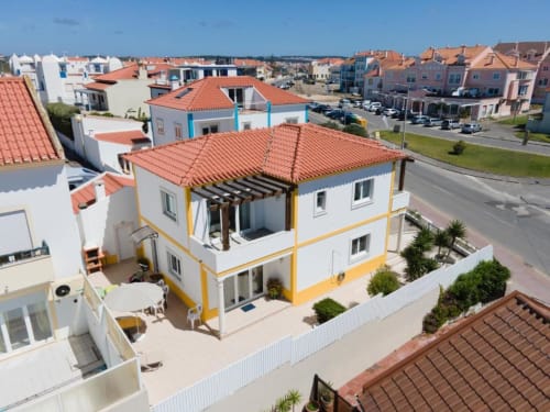 Villa Baleal Sunset Residence em Bombarral com fachada branca e amarela, telhado de terracota e pátio privado em Portugal