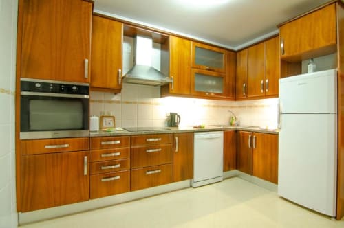 Cozinha moderna em madeira com eletrodomésticos brancos na villa Baleal Sunset Residence, Bombarral, Portugal