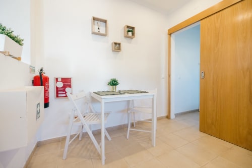 Modern dining area in Figueira House villa at Tree House, Sesimbra with white table, chairs, and wooden sliding door