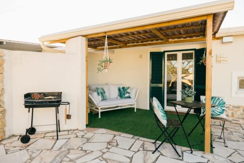 Figueira House villa patio with wooden pergola, white seating, black BBQ grill, and green lawn at Tree House Quinta Do Conde,