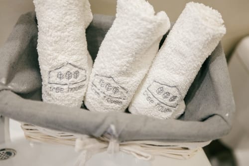 Tree House villa towels with embroidered logo, rolled in gray fabric at Quinta Do Conde, Sesimbra