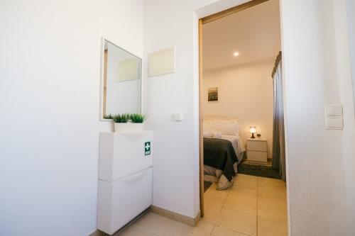 Casa Laranjeira villa entrance at Tree House, Sesimbra - hallway with mirror, first aid kit, and bedroom view