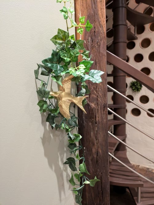 Climbing ivy with golden bird decoration on wooden post at Manoir Saint Joseph, Sens