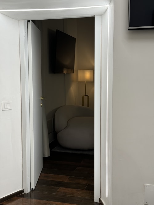 Moderna entrata della camera da letto presso Enjoy House Bracciano con letto e TV a parete in appartamento con pavimenti scuri