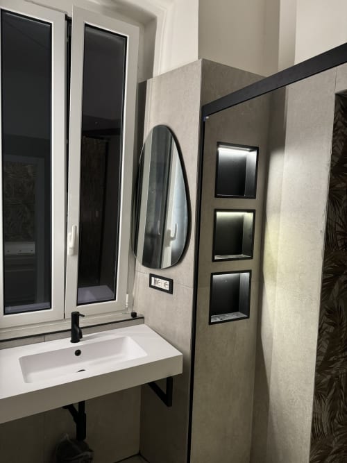 Moderno mobile bagno con specchio ovale e tre ripiani presso l'Enjoy House Bracciano apartment hotel a Bracciano, Italia