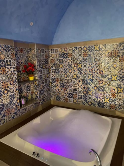 Lussuoso bagno con vasca idromassaggio illuminata e piastrelle decorative portoghesi presso San Nicola Suite Mini Apartments, Sorrento