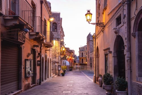 Affascinante via di Taormina al tramonto con edifici storici, eleganti lampioni e architettura tradizionale vicino a ToviMar