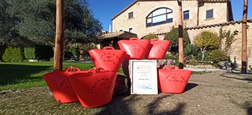 Installation artistique de protestation rouge à l'hôtel boutique Can Gat Vell à Gérone, Catalogne, avec bâtiment en pierre et jardin